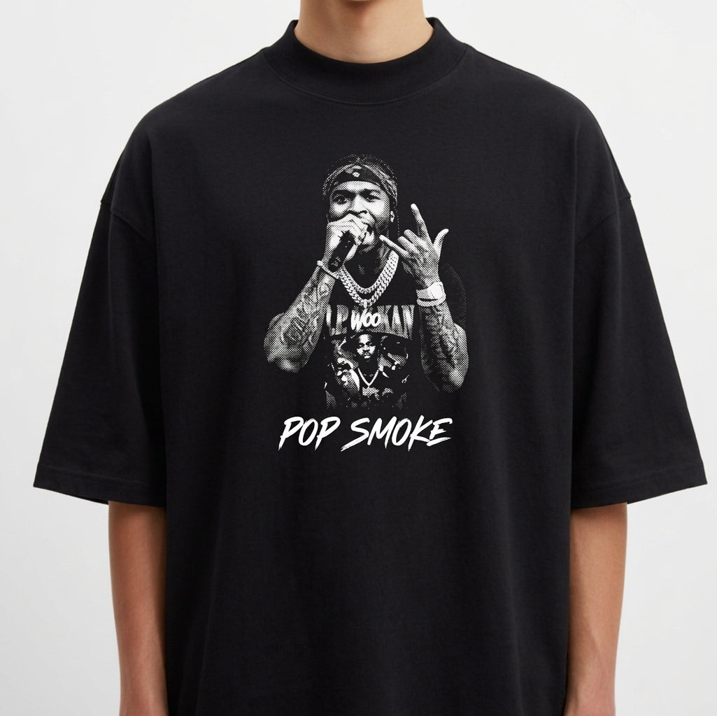 Camiseta com estampa frontal de cantor segurando microfone com colares, tatuagens e a frase "Pop Smoke" logo abaixo da imagem detalhada.